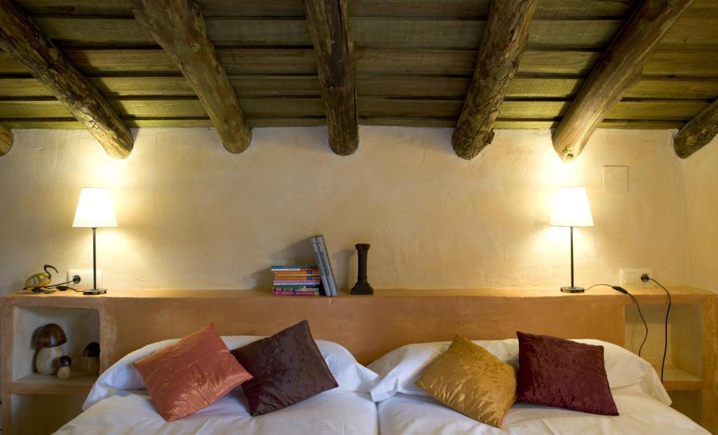 Habitaci&oacute;n con vigas de madera y cama acogedora